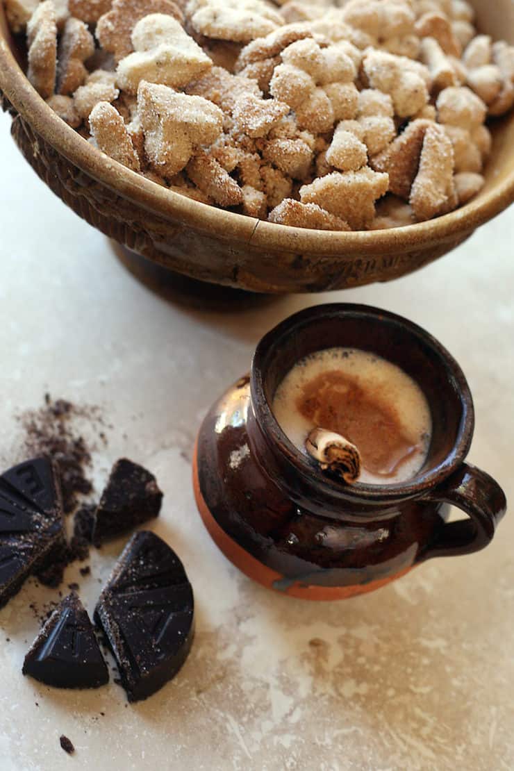 biscochos (Mexican wedding cookies) in a wooden bowl with a side of Mexican hot chocolate 