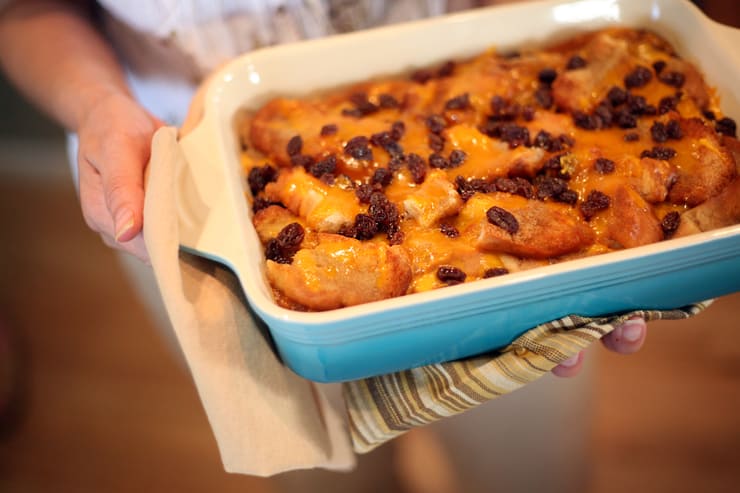 Holding delicious and authentic Capirotada or Mexican bread pudding in hands above the floor