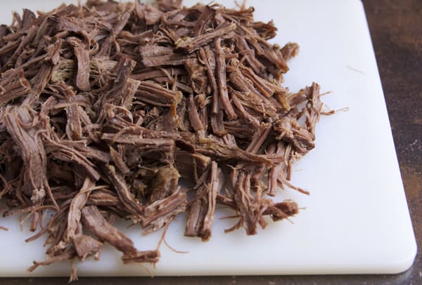 slow cooked shredded beef brisket on a cutting board