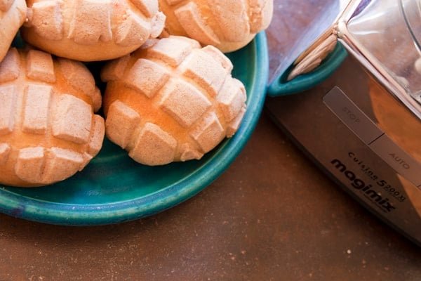 conchas pan dulce on a teal plate with a magimix food processor 