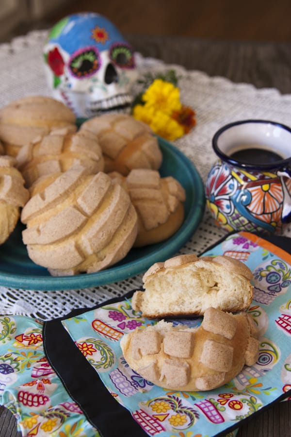 concha Mexican sweet bread with a coffee cup and in the background a sugar skull