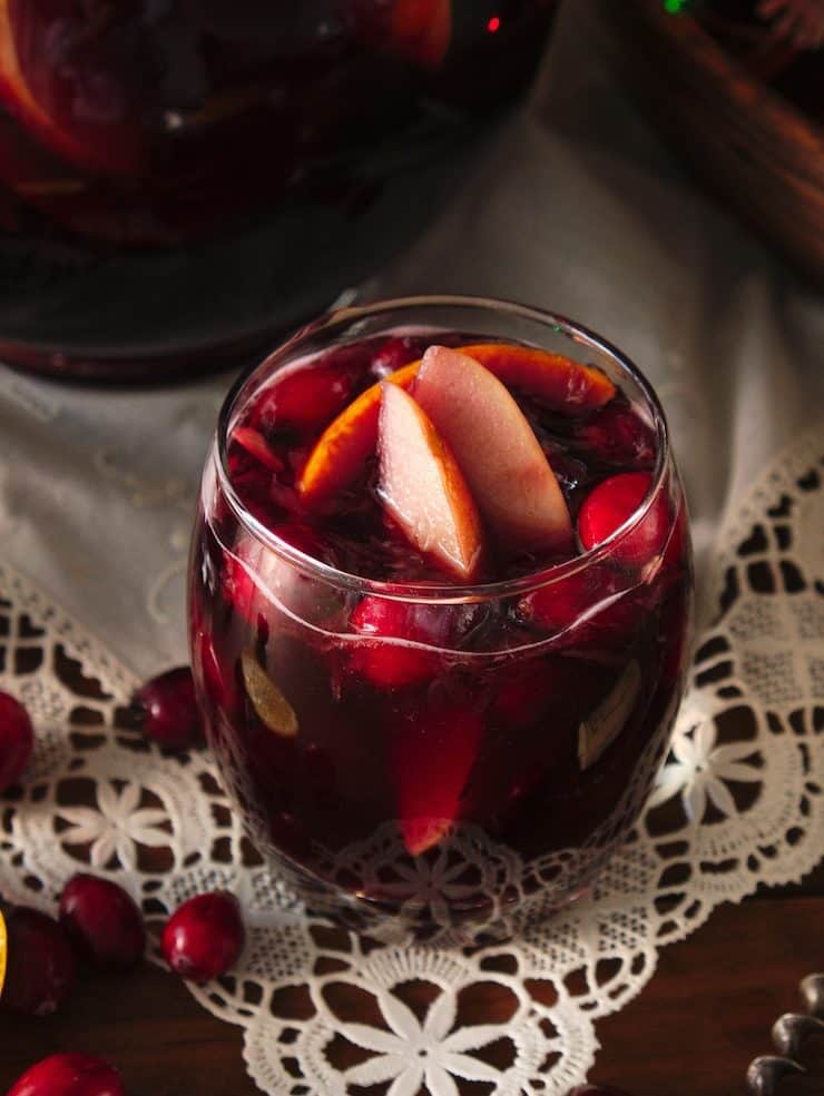 glass of red Christmas Sangria under white linen