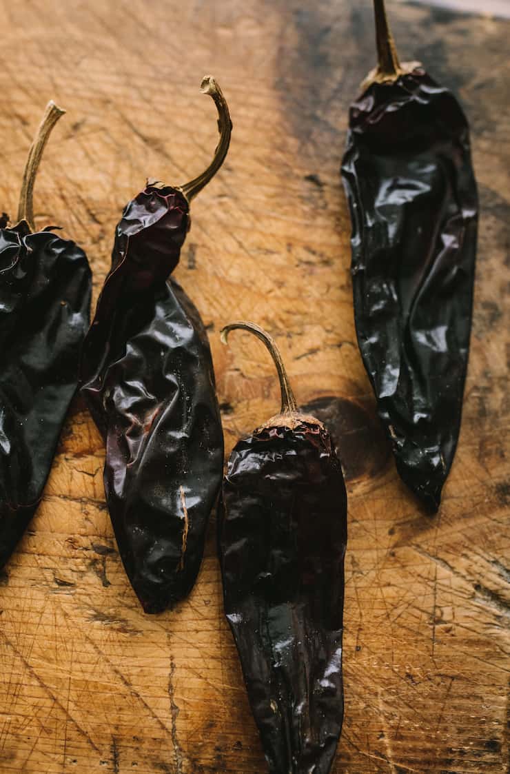 four colorado chiles on wood cutting board