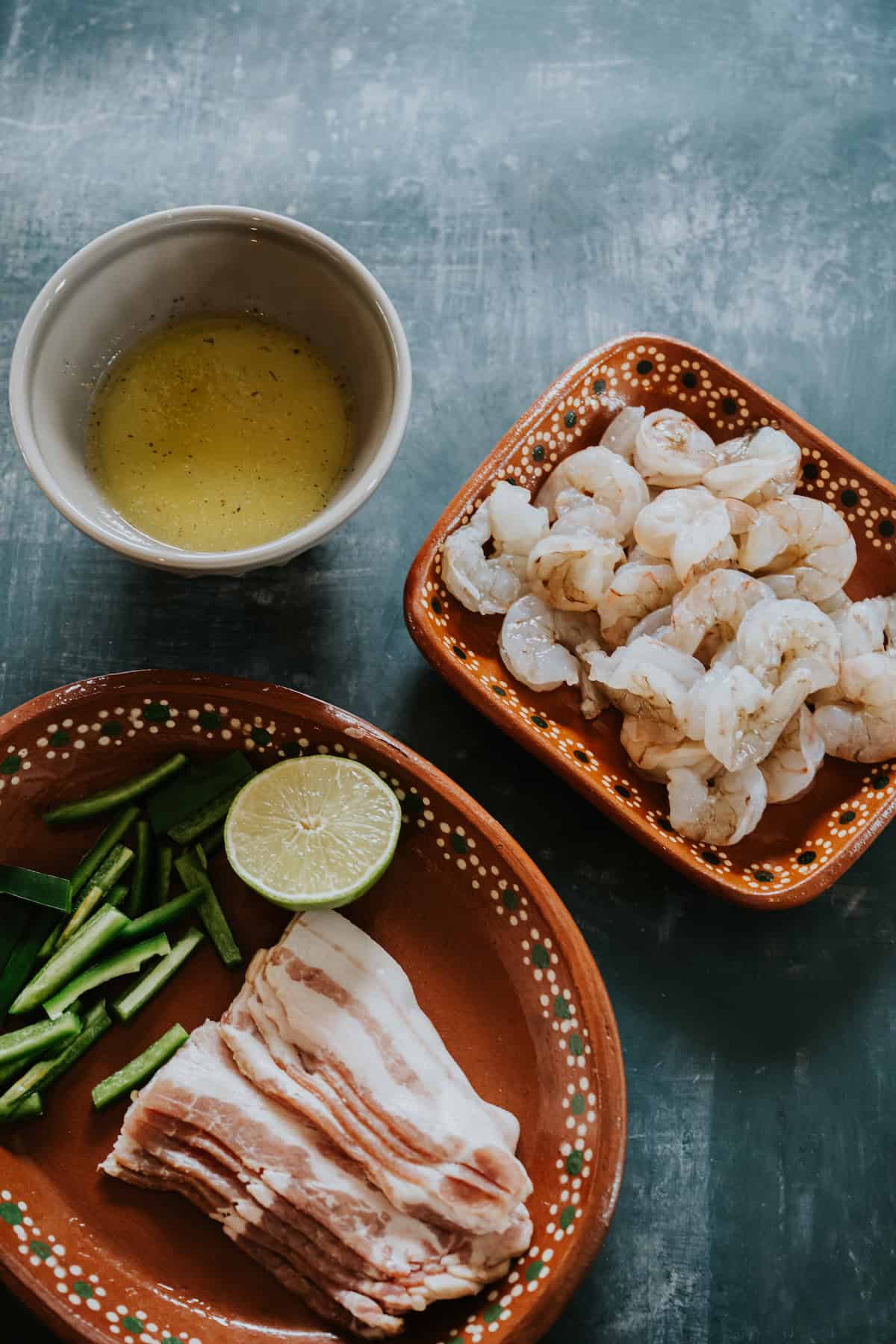 Ingredients for Bacon-Wrapped Shrimp with Jalapeño including shrimp, bacon, jalapeños, lime, and garlic-lime butter.
