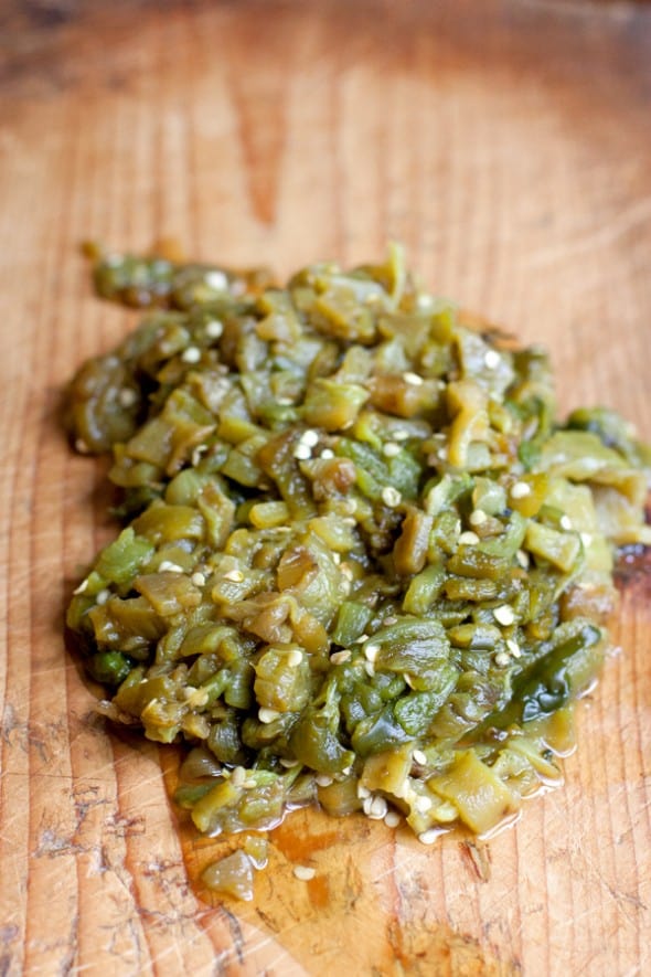 Chopped roasted Hatch green chile peppers on a cutting board for empanada filling.