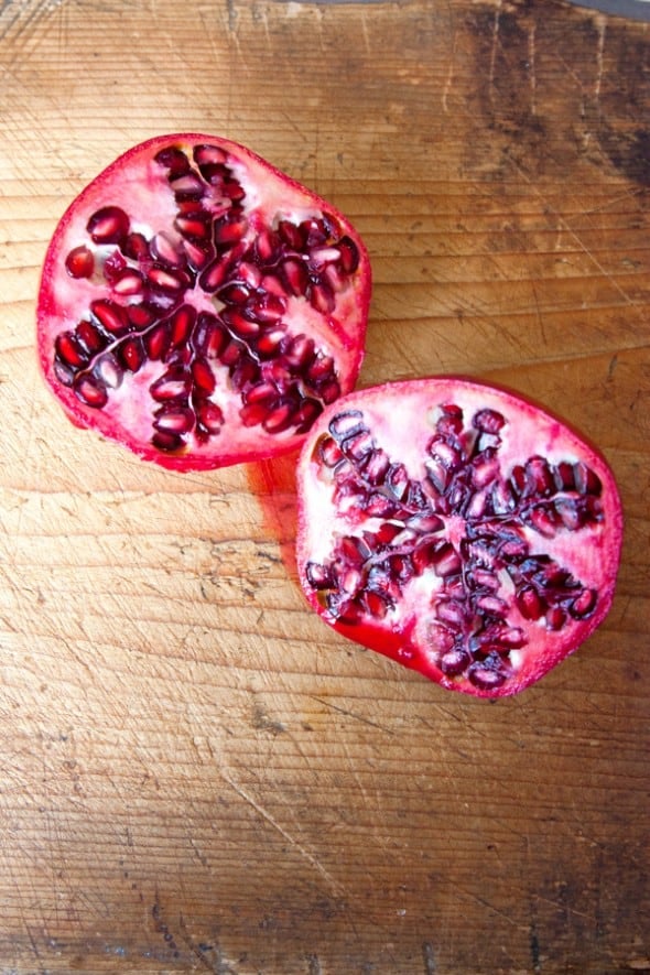 open pomegranate on a wooden cutting board