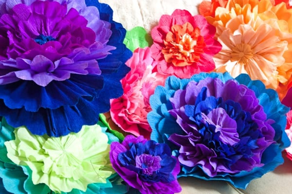 pile of homemade paper flowers in different colors.