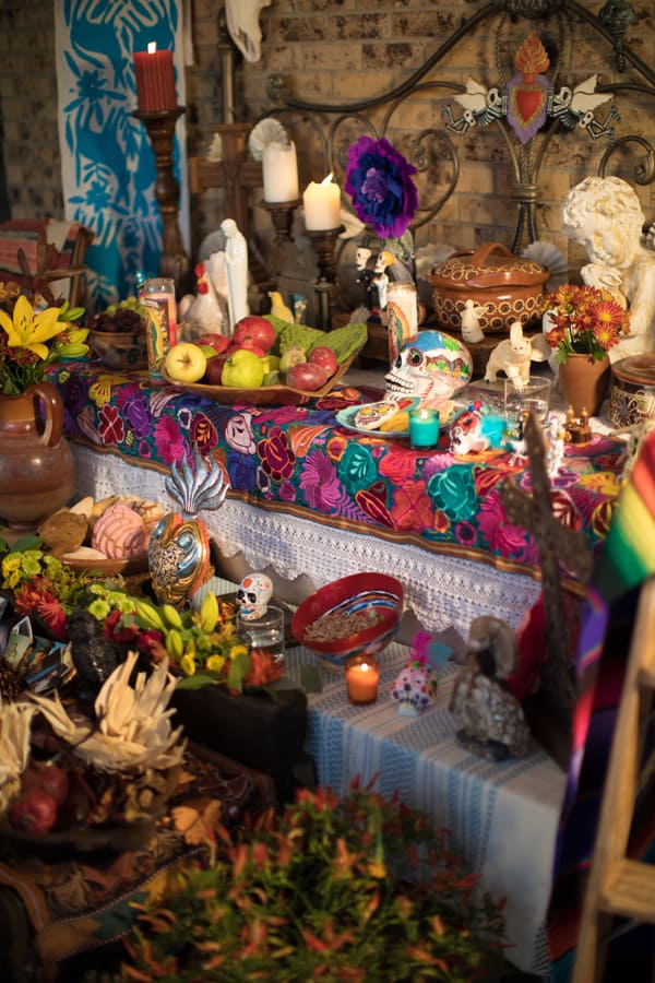 candles lit on altar for dia de los muertos 