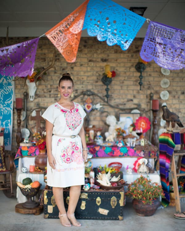 papel picado hanging above a day of the dead altar with Latina food blogger and Emmy winner