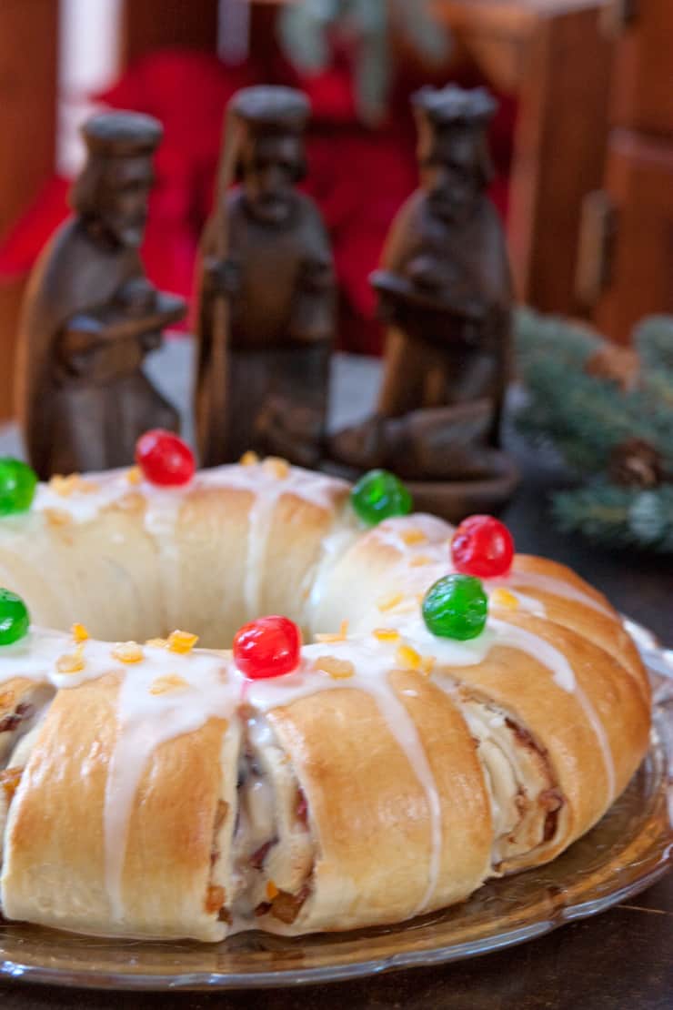 baked three kings day rosca de reyes recipe with three wooden kings in the background