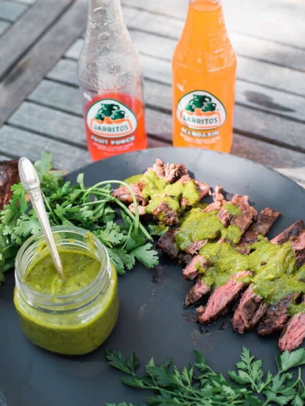 Grilled Skirt Steak with Chimichurri Sauce with two bottles of Jarritos on a wooden table