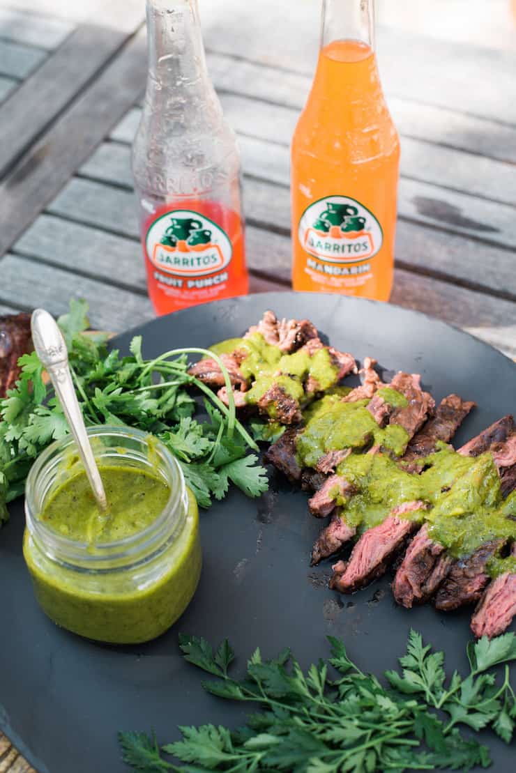 Grilled Skirt Steak with Chimichurri Sauce with two bottles of Jarritos on a wooden table