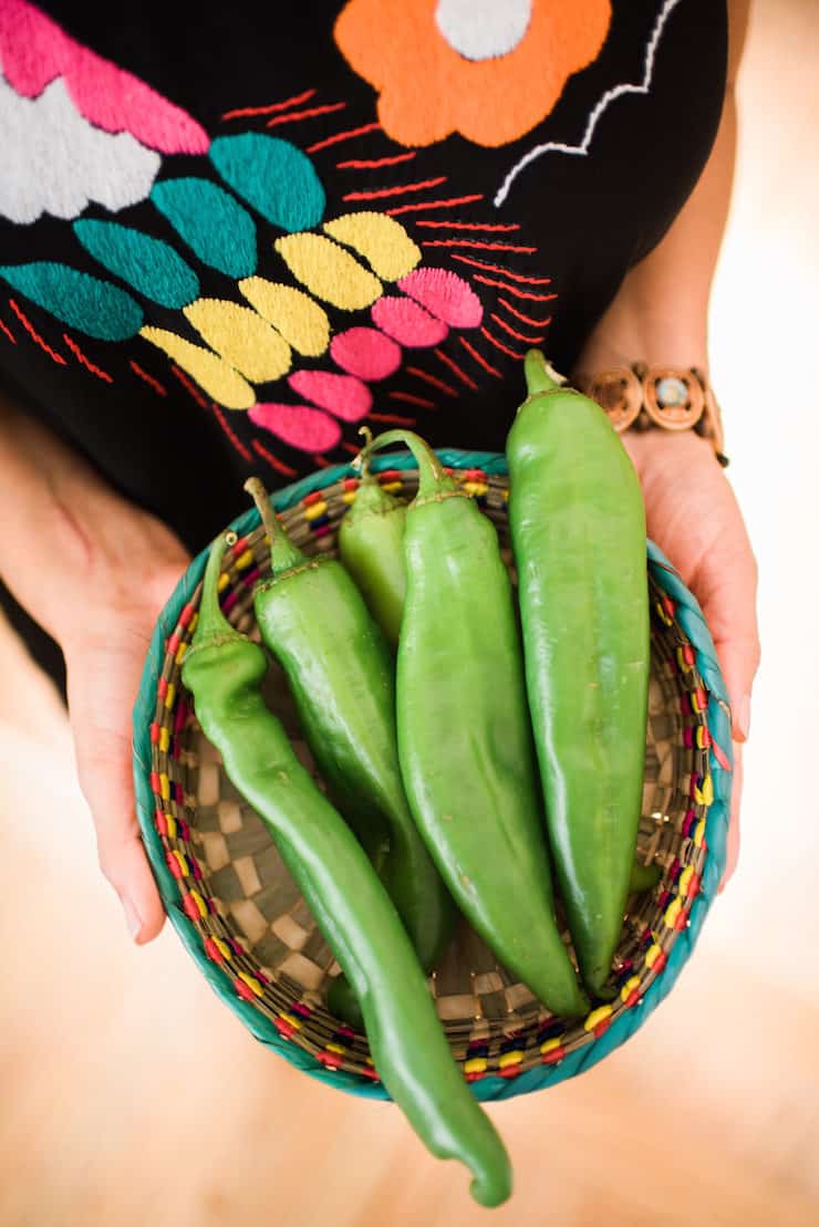 hands holding a basket with fresh Hatch Chile
