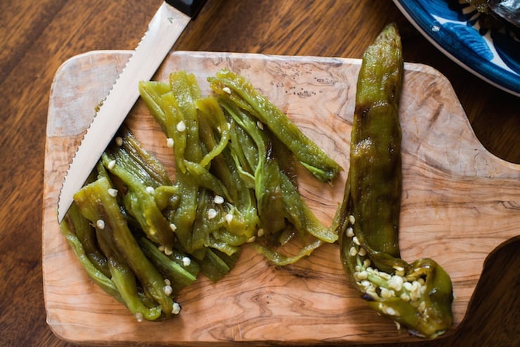 roasted and peeled hatch green chiles on a wooden cutting board