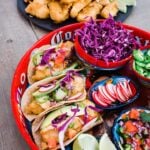 beer battered baja fish tacos on a red platter