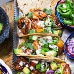 Shripm Tacos recipe served on a tray with pita bread, parsley and a few bowls with deliciousness on the side