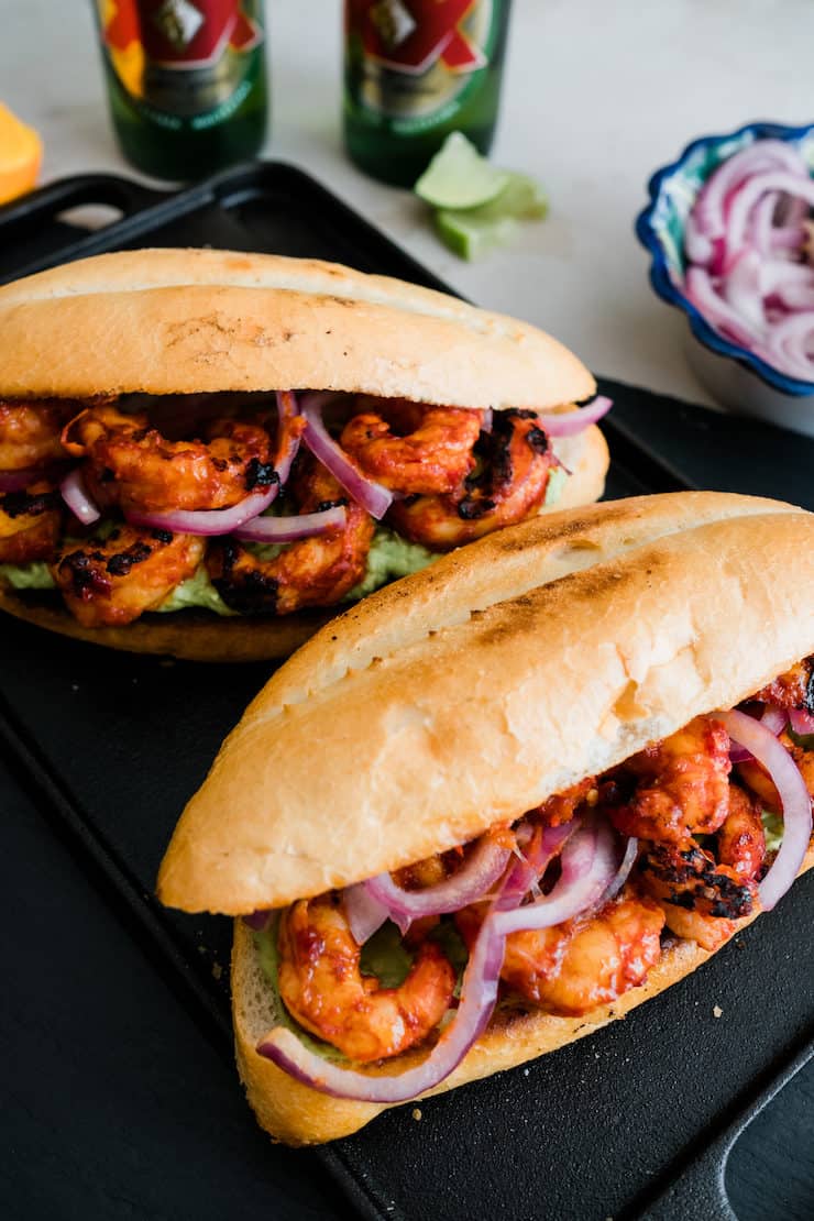 two spicy shrimp tortas on a black plate