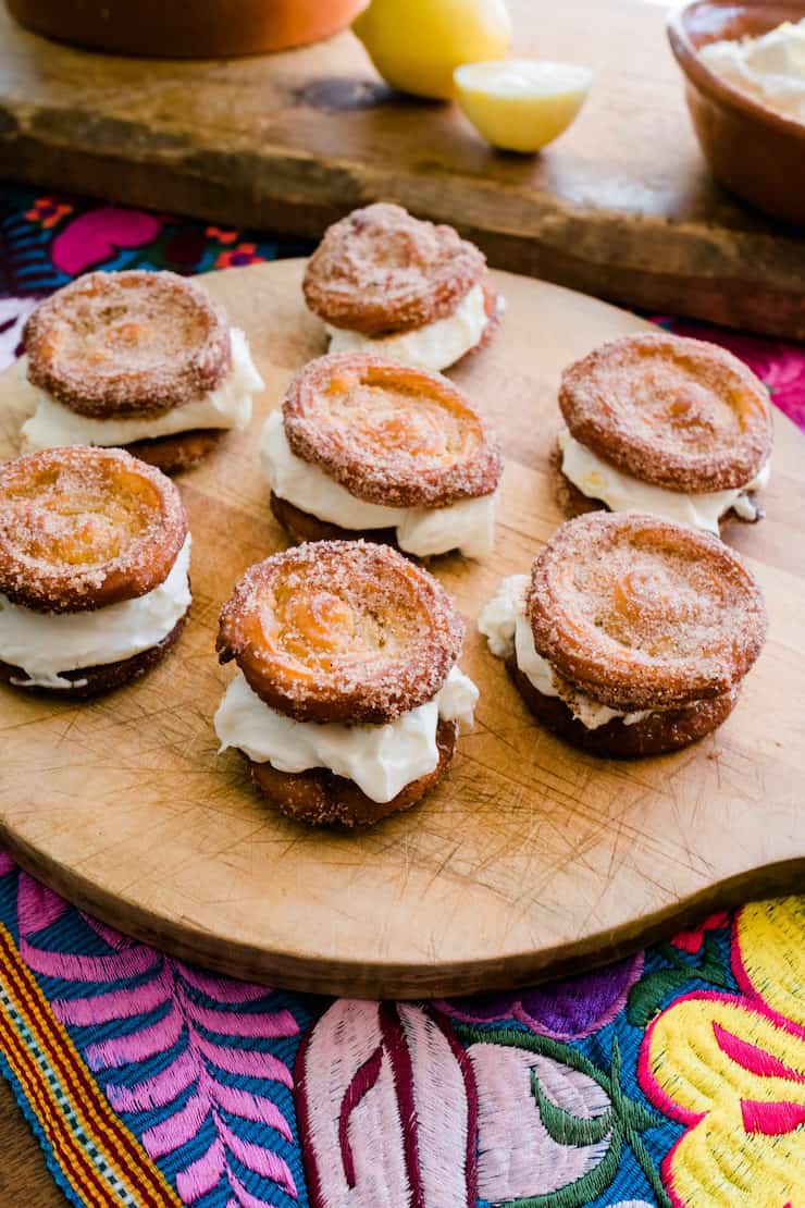 Serving delicious Churro Lemon Cream Sandwiches on a wooden board with lemon in the background