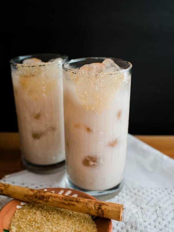 Two glasses filled with ice and horchata with tequila