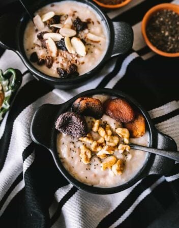 Oatmeal with dried fruit and nuts inside a dark bowl