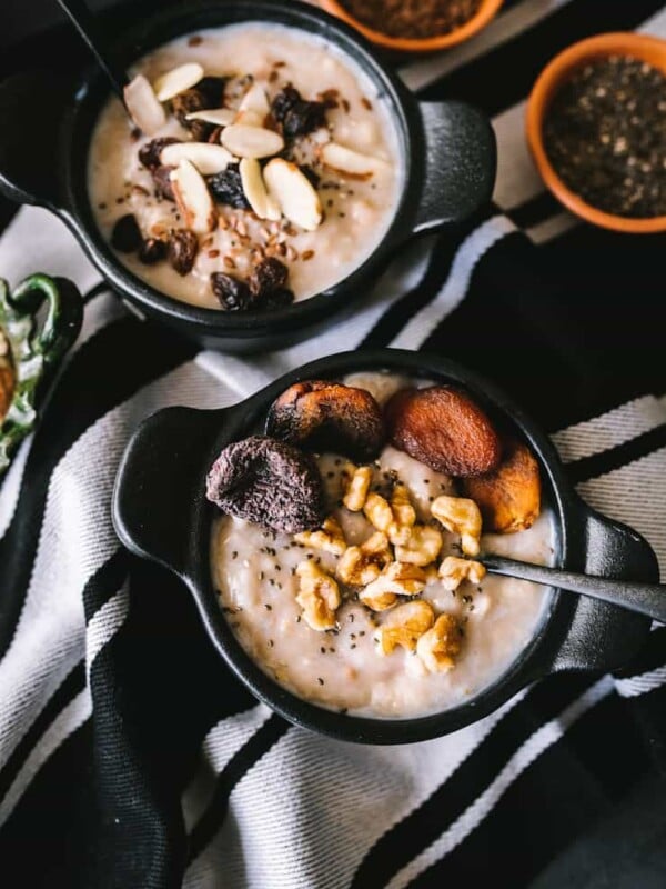 Oatmeal with dried fruit and nuts inside a dark bowl