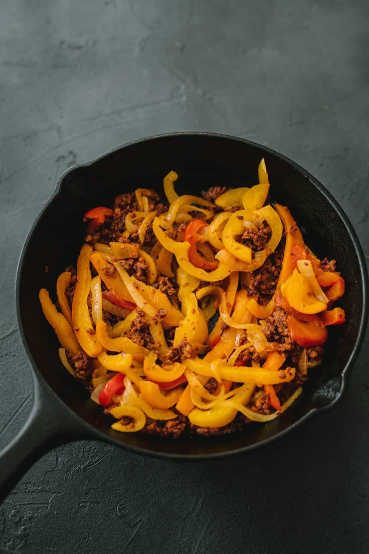 a skillet of sautéed bell peppers and onions for Choriqueso (Queso Fundido with Chorizo)