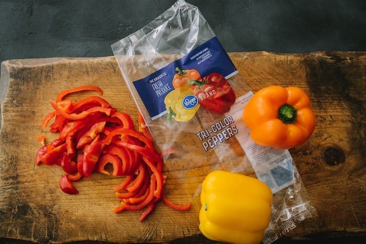 colorful bell peppers on a wooden cutting board for Choriqueso (Queso Fundido with Chorizo)
