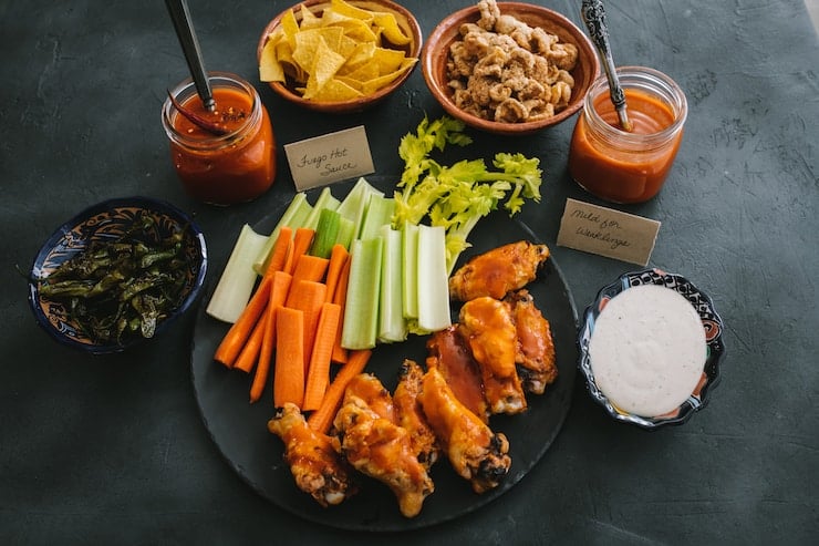 chicken wings platter with sauces celery and carrots