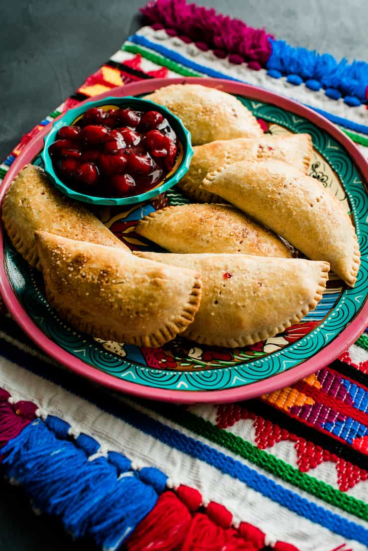 Cherry Empanadas (Cherry Hand Pies) on a colorful plate and placemat