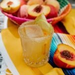 palomo peach drink on the rocks on a yellow striped serape