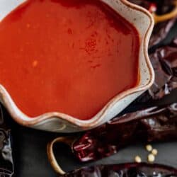 homemade enchilada sauce in a bowl surrounded with dried Chile pods