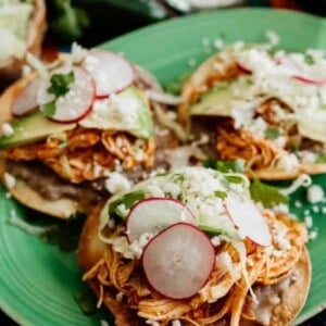 chicken tinga tostadas on a green plate