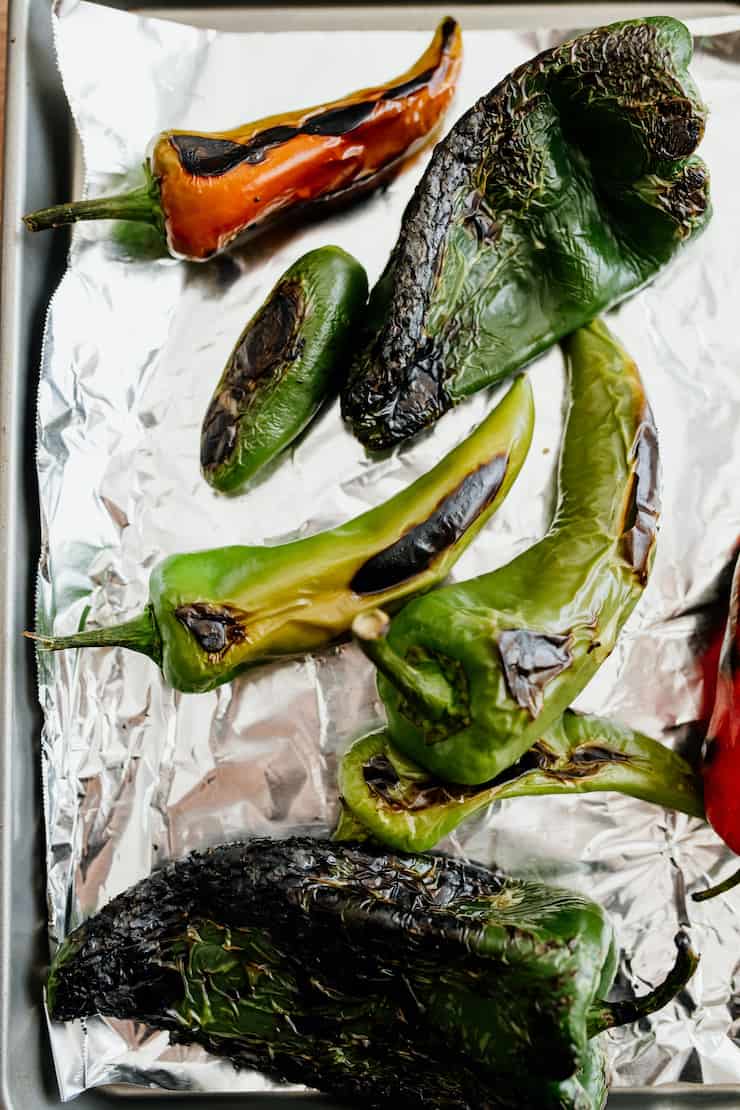 assorted roasted Mexican chiles on a foil lined tray