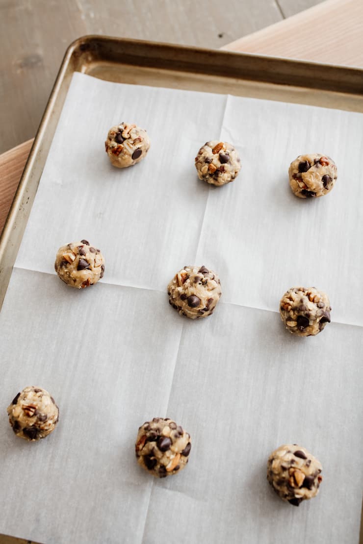 cookie dough balls on a parchment lined cookie sheet