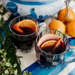 mulled wine in clear mugs on a blue and white tablescape