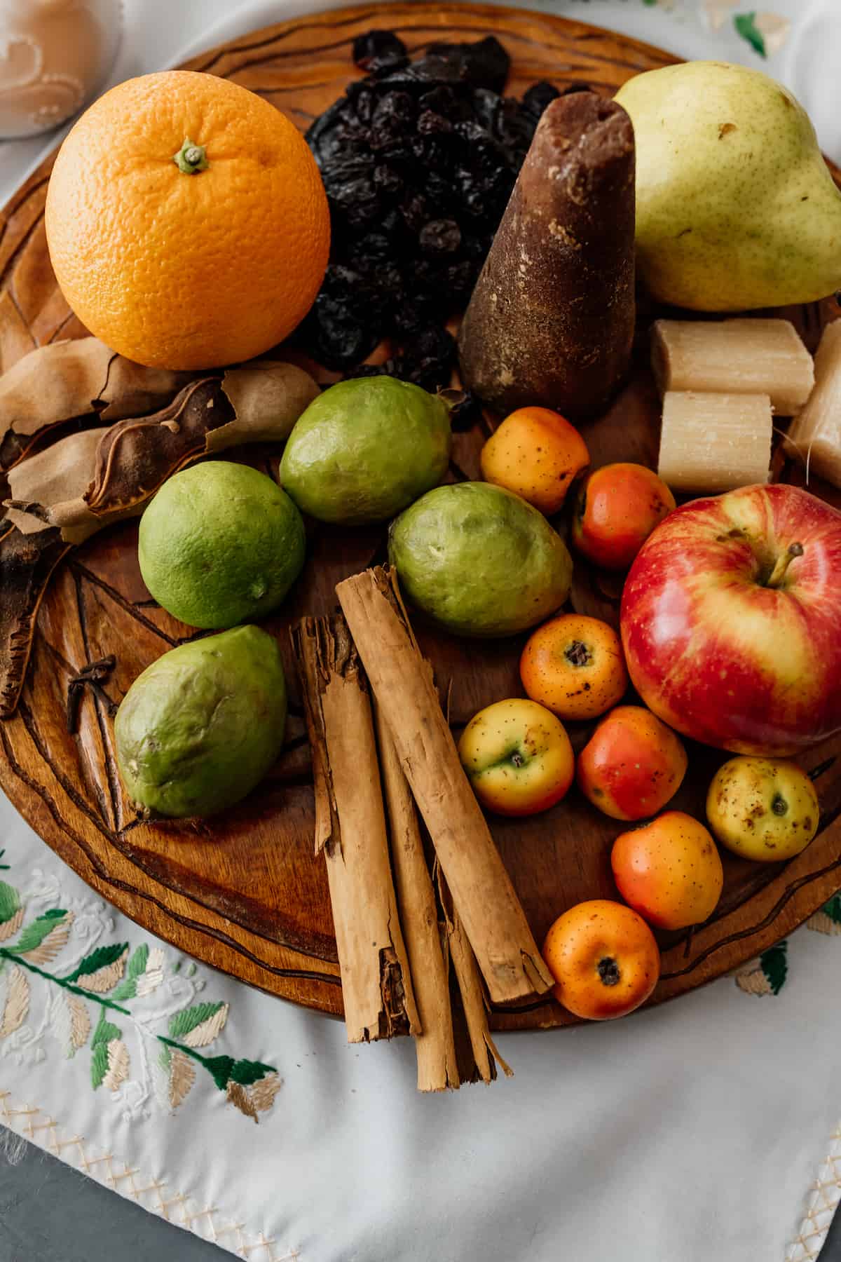 Mexican fruits and spices to make poncho navideno on a wooden board