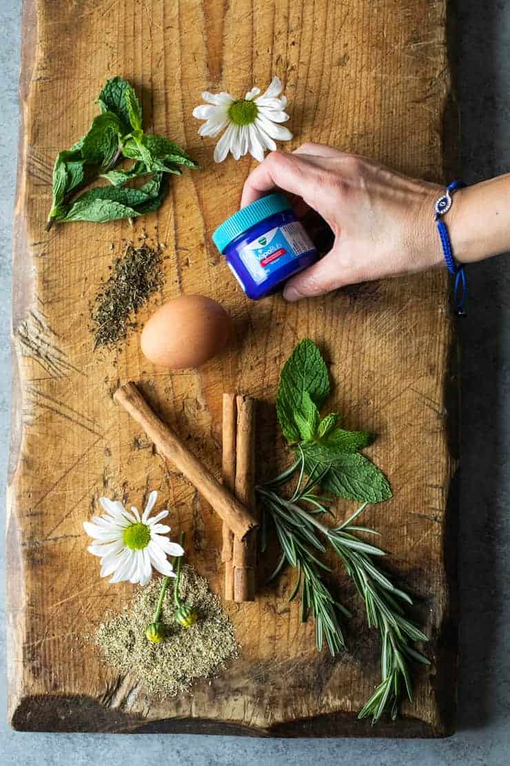 wooden board with fresh herbs and other common traditional Mexican remedies mint chamomile Vicks rosemary 