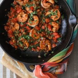 black cast iron sauté pan filled with cooked ranchero style shrimp