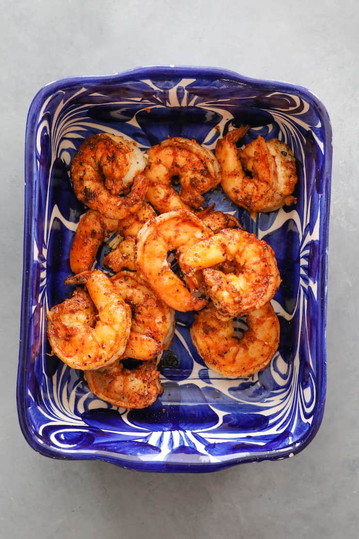 overhead shot of cooked camarones in a blue and white bowl