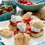 homemade strawberry shortcakes on a white platter with a turquoise linen