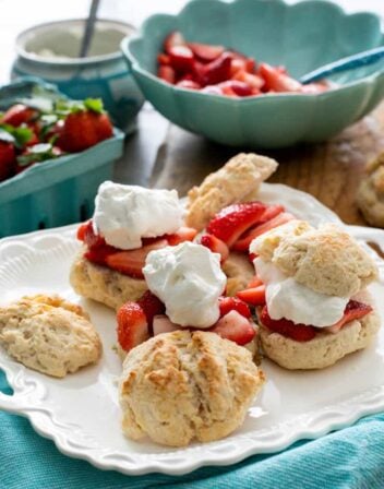 homemade strawberry shortcakes on a white platter with a turquoise linen