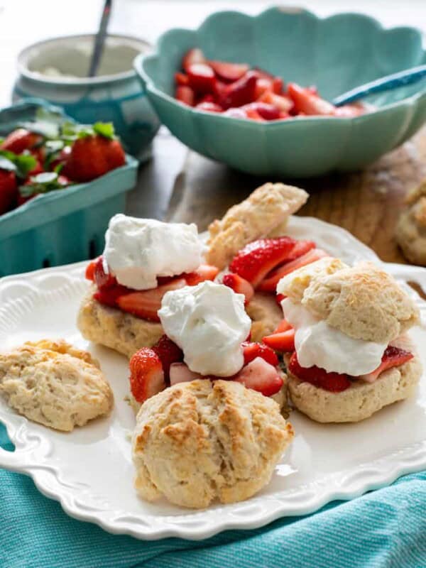 homemade strawberry shortcakes on a white platter with a turquoise linen