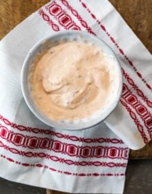 creamy chipotle sauce in a white bowl on a white and red patterned tea towel