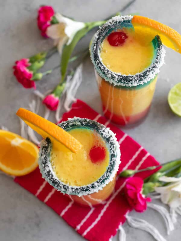 overhead shot of frozen sunrise margaritas in tall collins glasses with salted rims