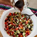 pouring dressing onto grilled nopales salad