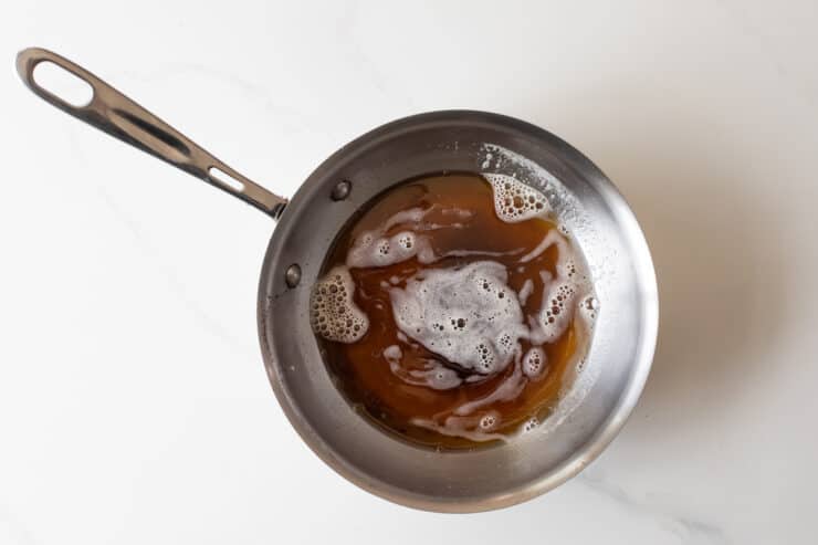 brown butter in a pan on a white marble surface background 
