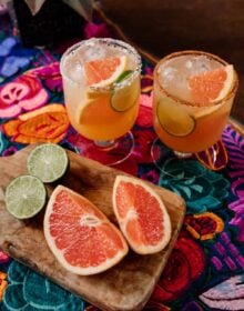 two Paloma cocktails with fresh citrus on the side