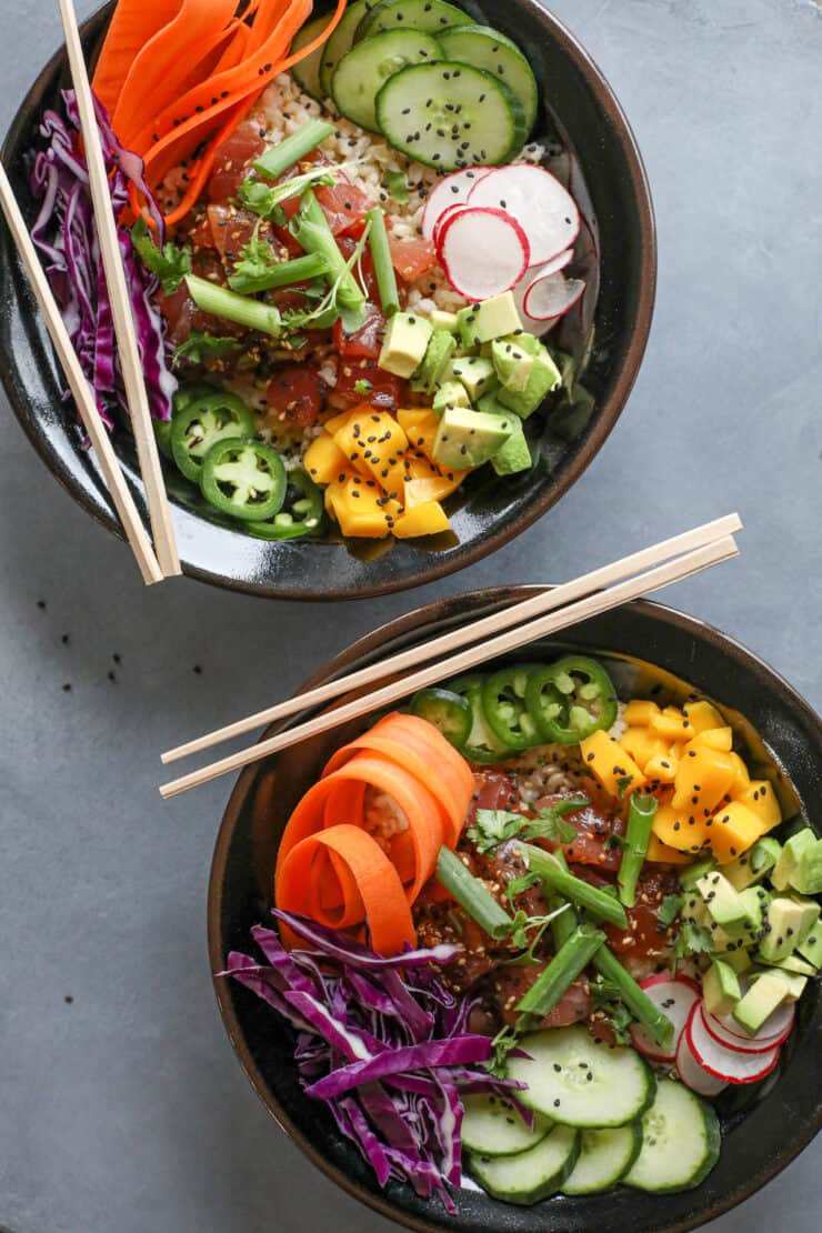 overhead shot of two bowls filled with spicy tuna poke and all the fixings 
