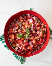 overhead shot of a red bowl filled with strawberry salsa
