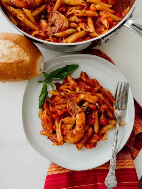Chipotle Shrimp Penne on a white plate with a red cloth napkin and fork